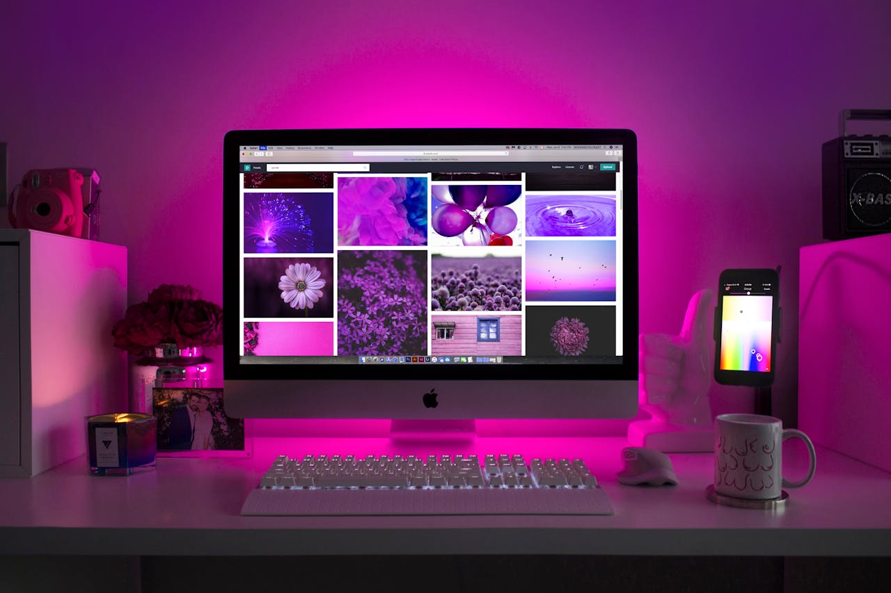 heros-img Modern desk setup with neon lighting and a desktop computer displaying colorful images.